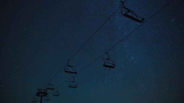 Night sky timelapse with moving Milky Way galaxy stars and shooting star meteor trails over mountain silhouettes at Babin Zub in Stara Planina nature reserve, Serbia.