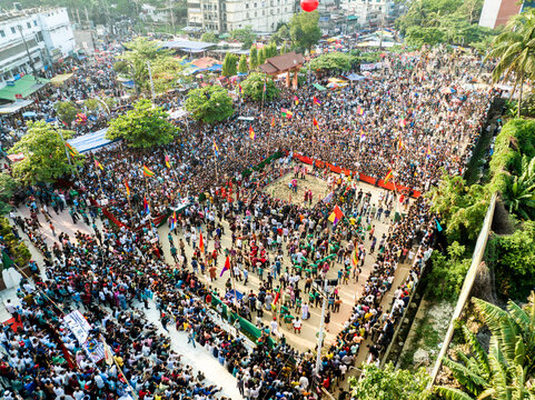 Chattogram, Chittagong, Bangladesh - 25 April 2024: Aerial view of a large crowd gathered in an open square for a cultural festival, with colorful flags and spectators surrounding a central arena.