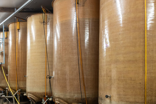 Traditional apple cider production equipment, fiberglass fermentation tanks on small family farm in Pays d'Auge, Normandy, authentic artisanal cidery methods and regional specialty