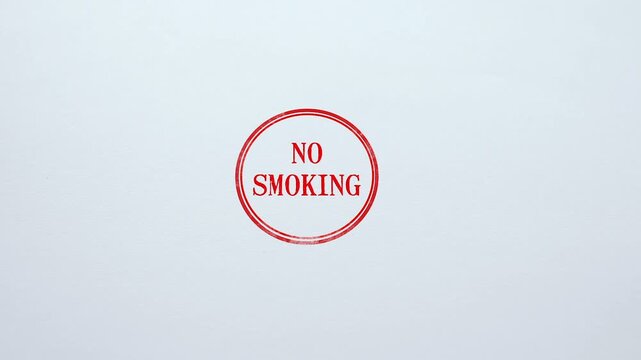 A minimalist circular red rubber ink stamp impression featuring the text no smoking centered on a clean white paper background