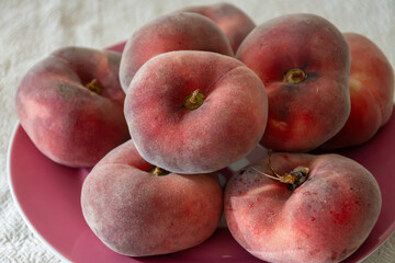 Flat peaches, Saturn sweet peaches from Mediterranean orchards, ripe Prunus persica seasonal fruit, harvest, orchard-grown fruit © barmalini