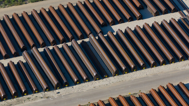 Aerial view of rows of brown arched industrial steel components stored in an outdoor yard in Ochten, Gelderland, Netherlands.