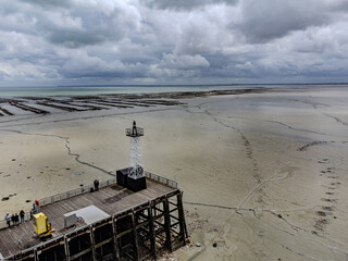 Aerial drone view of underwater oyster farms in Cancale, Brittany, exposed during low tide, raditional sustainable aquaculture and production of premium French oysters, France © barmalini
