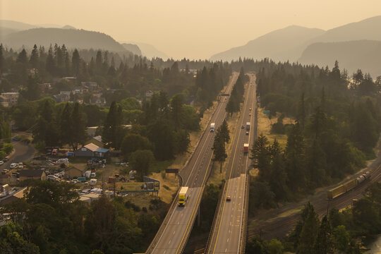 Aerial view of Interstate 84 highway with wildfire smoke obscuring the landscape, featuring trucks and cars traveling through Hood River, Oregon, United States.
