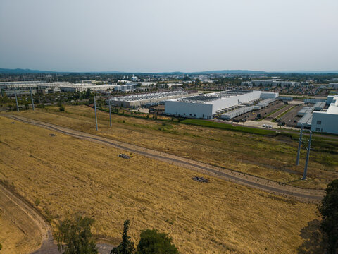Aerial view of Hillsboro data centers with large industrial buildings, expansive dry grassy fields, and power lines under a clear sky in Hillsboro, Oregon, United States.