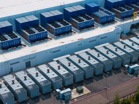 Aerial view of the Hillsboro data centers featuring rows of industrial cooling units and HVAC equipment on the roof and ground in Hillsboro, Oregon, United States.