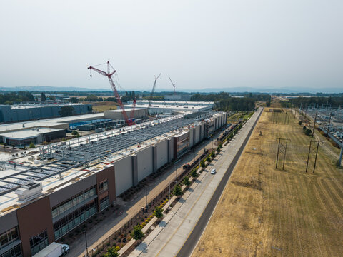 Aerial view of Hillsboro data centers under construction with large industrial buildings, cranes, and surrounding fields in Hillsboro, Oregon, United States.