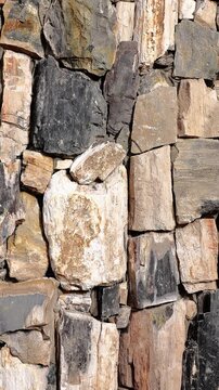 4K zoom in view of abstract rustic rock architecture wall cladding facade. Heavy solid geology elements and modern construction block patterns create a realistic backdrop for real estate art design.
