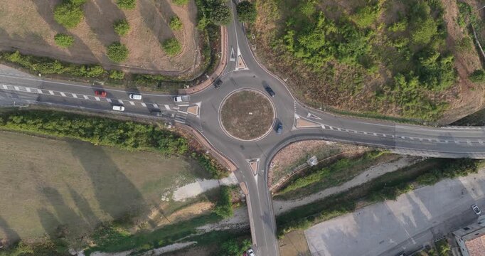 Aerial view of a roundabout with surrounding roads, green fields, and trees in Spoleto, Umbria, Italy.