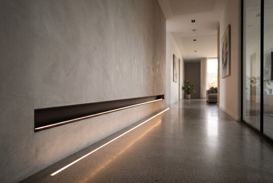 Wall with integrated lighting slot casting thin line of light on floor