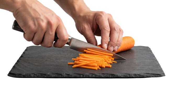 PNG cut out isolated background. A close-up shot of a person's hands using a chef knife to slice a fresh orange carrot into fine julienne strips on a dark slate cutting board.