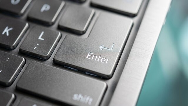 Digital Command: Close-up of 'Enter' Key on a Modern Silver Laptop Keyboard
