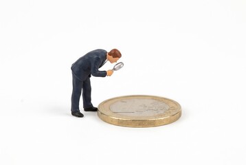 Obraz premium ユーロ硬貨を観察するビジネスマン