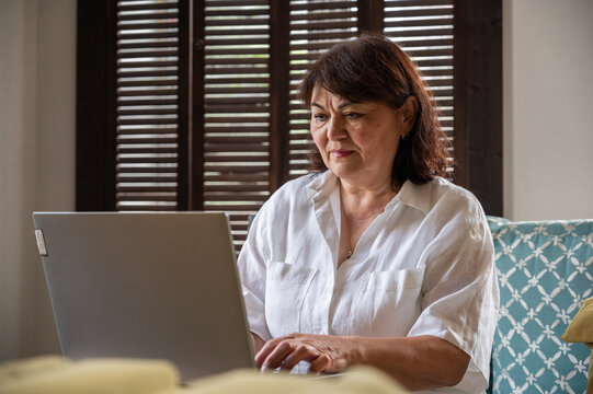 Concentrated senior female teacher or businesswoman using laptop