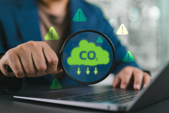 Business professional analyzing carbon emissions, CO2 data, carbon footprint, ESG reporting, climate compliance, sustainability, and environmental risk management using a laptop.