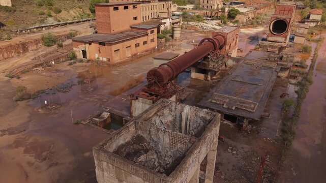 Monteponi mining site in Iglesias, Sardinia, Italy, showing historic mining structures and industrial buildings within the former lead, silver and zinc mining complex - drone shot