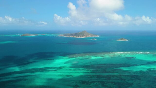 High altitude aerial shows Petite Martinique, Petit Saint Vincent and Petite Dominique scattered across turquoise Grenadine waters and coral reefs