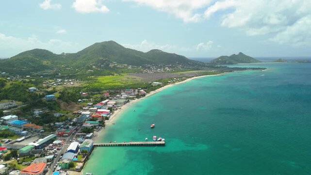 Aerial parallax glides over Hillsborough Bay in Carriacou, Grenada past Mont Chapeau Carre, Mabouya and distant Sandy Island in turquoise water