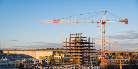 Tower cranes and building framework at active construction site © Alif