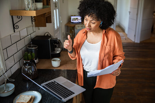 Woman on video call working in home kitchen