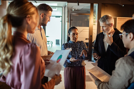 Diverse team discussing charts in modern office