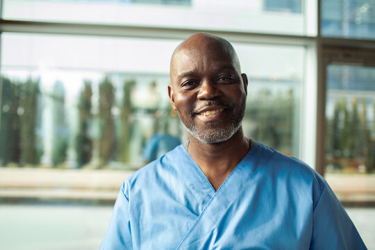 Smiling male nurse portrait in hospital lobby