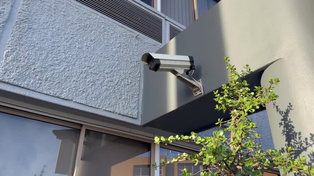 A surveillance camera outside an office block.