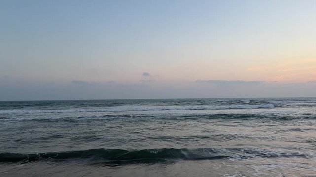 Ocean waves rolling towards the shore at dusk