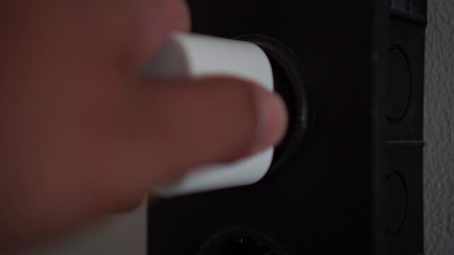 Person take out phone charger from power socket, close up shot, electrical outlet connection, home technology footage scene.