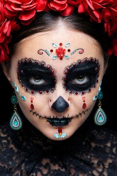 Halloween beauty close-up portrait of woman. Beautiful female face adorned with Santa Muerte makeup.