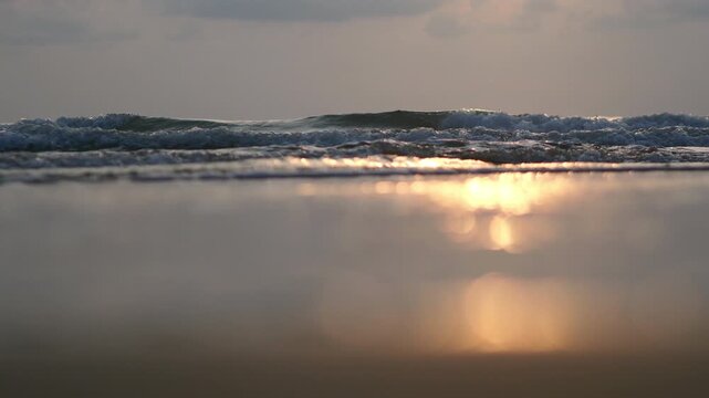 A summer ocean sunset sea background with small waves on the water's surface in lights from sunrise
