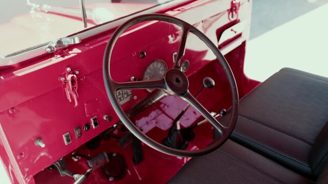 Steering wheel gear lever and pedals inside the red cab of a vintage fire truck