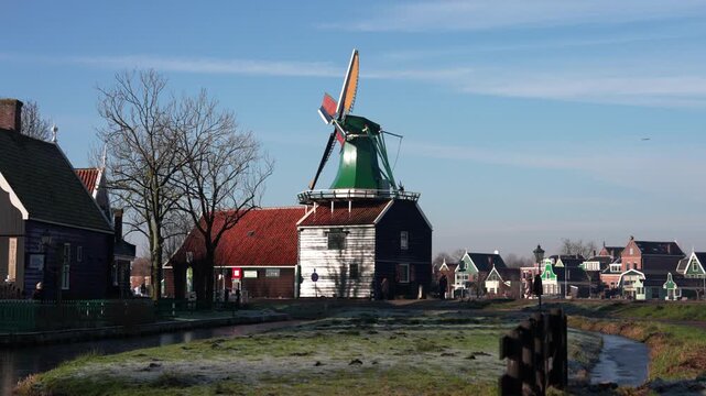 オランダの伝統的な風車と木造家屋が並ぶ冬の村の風景（Traditional Dutch Windmill and Wooden Houses in Winter, Netherlands）