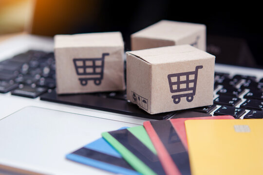 Shopping online. Credit card and cardboard box with a shopping cart logo on laptop keyboard. Shopping service on The online web. offers home delivery