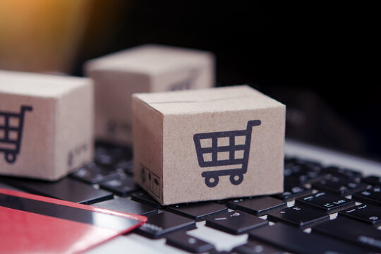 Shopping online. Credit card and cardboard box with a shopping cart logo on laptop keyboard. Shopping service on The online web. offers home delivery