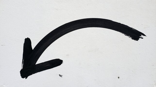 Wide arched black marker arrow with a smooth downward curve painted on a white wall. Ideal for pointing, wayfinding, and directional concepts.