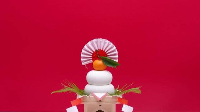 鏡餅を中央に配置し、赤白背景でティルトダウン撮影した動画　低い三宝あり