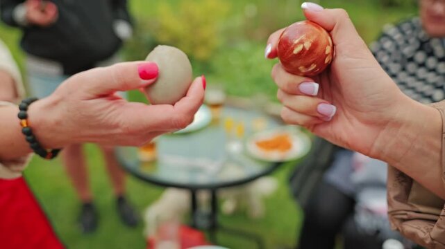Decorated Easter egg cracks on impact, marking a defeat in a springtime contest