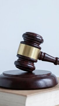 Dark Wooden Gavel Striking Law Book for Legal Justice Authority and ESG Ethical Governance Concept in Professional Studio Setting