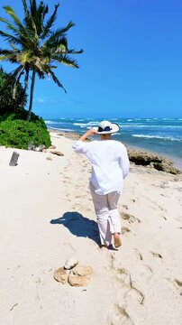 A woman in white outfit on an empty beach in Hawaii