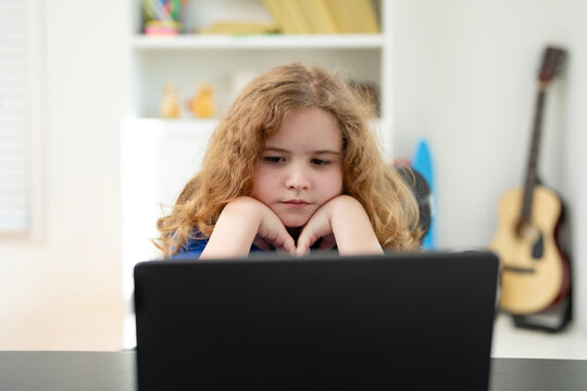 Child education typing homework on laptop. Child education in home workspace. Boy education in modern interior. Digital education for kids.