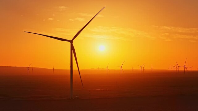 Solar photovoltaic panels at sunrise/sunset; wind turbine power plant; new energy