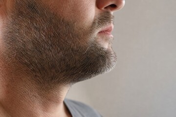 Fototapeta premium Macro of single silver beard hair on mature man's stubble jawline