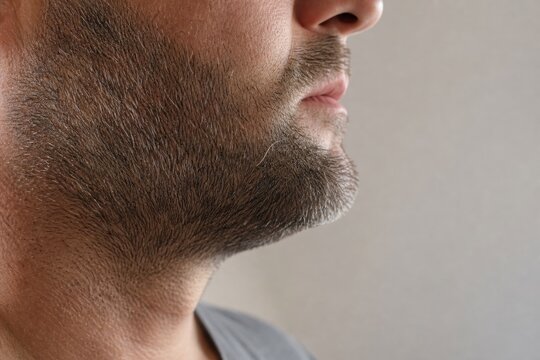 Macro of single silver beard hair on mature man's stubble jawline