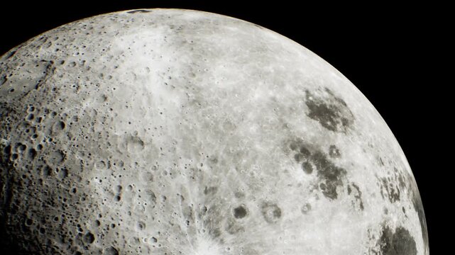 The surface of the moon with clear details of craters and dark areas. It captures the moons texture and geological features at night.