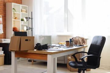 Fototapeta premium Remote work and home office setup empty desk with laptop camera and moving boxes freelance creative workspace