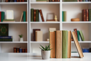 Books with plant on table in home library