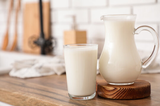 Jug and glass of fresh milk on counter in kitchen
