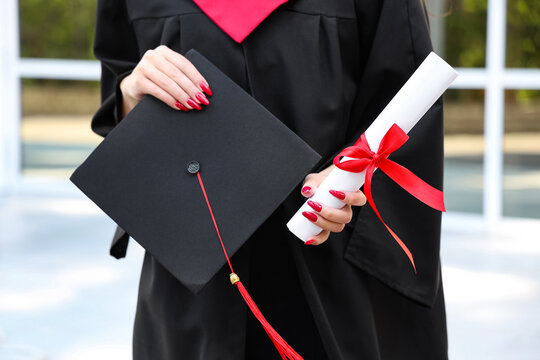 Female student with diploma on her graduation day, closeup