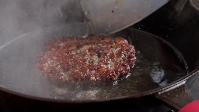 flipping hamburger patty, browning and crusty meat patty, home cooking concept